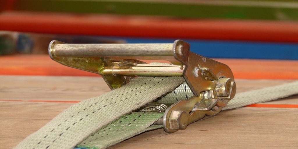 ratchet strap tie-down securing cargo on flatbed trailer