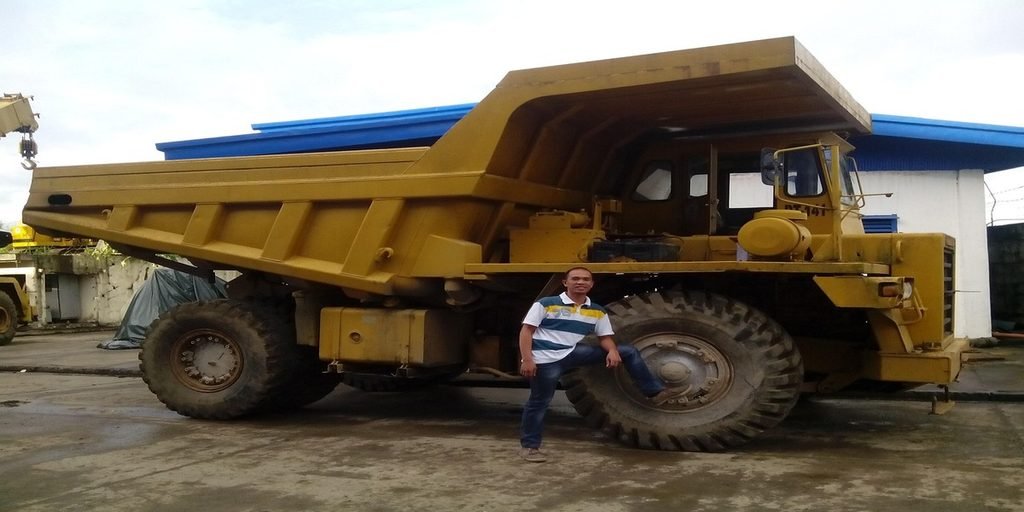 truck driver inspecting flatbed load before departure